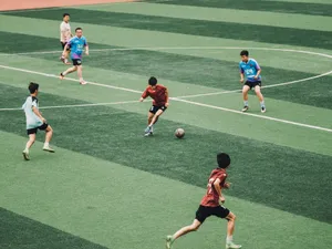 Action shot of teenagers playing soccer on a green sports field. jigsaw puzzle
