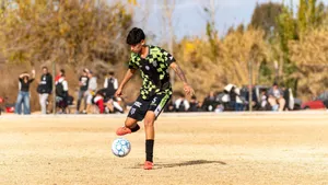 A young soccer player skillfully dribbles the ball on a sunny day field, showcasing agility and focus. jigsaw puzzle