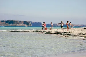 A sunny day at Balos Lagoon in Greece with people enjoying the beach and clear blue waters. jigsaw puzzle