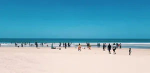 People enjoying a sunny day at Colva Beach in Goa, India, with clear blue skies and sandy shores. jigsaw puzzle