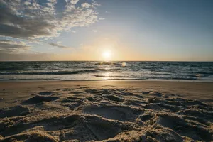 Peaceful sunset over sandy beach and gentle ocean waves, capturing a tranquil seascape. jigsaw puzzle