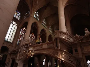 Explore the stunning gothic interior of a Paris church featuring stained glass and intricate arches. jigsaw puzzle