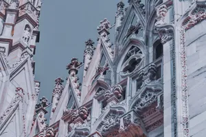 From below exterior details of Milan Cathedral with ornamental elements and sculptures under gray sky jigsaw puzzle
