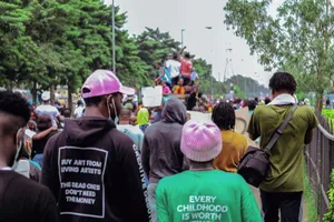 A crowd of diverse individuals at a street event captured from behind. jigsaw puzzle