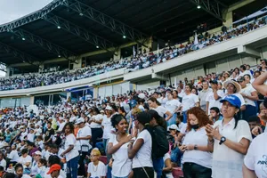 A vibrant crowd gathers in a stadium, enjoying an exciting event under a covered roof. jigsaw puzzle