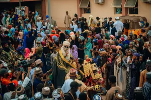 Vibrant street scene of people in traditional attire during a Nigerian festival with a lively atmosphere. jigsaw puzzle