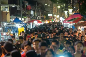 Lively night market scene with a crowded street filled with people and vibrant stalls. jigsaw puzzle