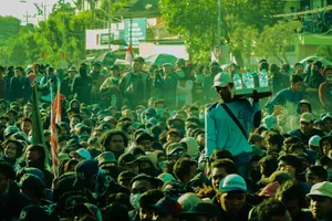 Large crowd of people gathered outdoors with a vendor selling bottled water, creating a lively street scene. jigsaw puzzle