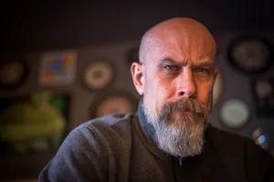 Close-up portrait of a bald man with a beard in an artistic indoor setting, showcasing a thoughtful expression. jigsaw puzzle