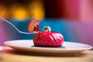 Delicious red dessert decorated with syrup and chocolate and placed on white plate on table jigsaw puzzle