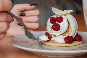 Close-up of a raspberry dessert with whipped cream and a fork on a plate. jigsaw puzzle