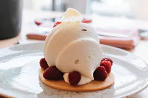 Delicious raspberry mousse cake garnished with fresh raspberries and cream, perfect for dessert lovers. jigsaw puzzle