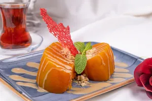 Elegant pumpkin dessert with mint garnish and cream sauce on a blue plate. jigsaw puzzle