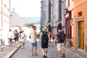A bustling stone road in a historic European city filled with tourists enjoying a summer day. jigsaw puzzle