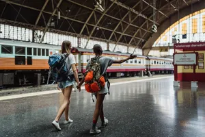 Two women with backpacks walking through a train station, showcasing adventure and friendship. jigsaw puzzle
