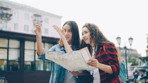 Two young women using a map to navigate an urban cityscape outdoors. jigsaw puzzle