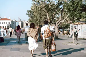 A couple strolls down a bustling city street surrounded by lush trees and vibrant urban life. jigsaw puzzle