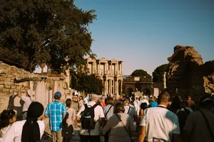 A group of tourists explore the historic ruins of Ephesus under a clear blue sky. jigsaw puzzle