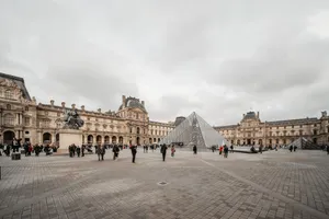 View of the Louvre Pyramid with tourists, capturing the historic facade and iconic glass structure. jigsaw puzzle