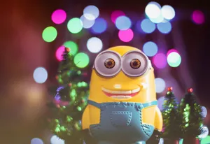 A cheerful minion toy among colorful bokeh lights and small Christmas trees. jigsaw puzzle