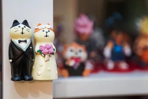 Charming cat couple wedding figurines showcased on a shelf with blurred background figurines. jigsaw puzzle