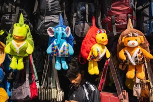 Vibrant plush toy backpacks hanging in a busy Colombo street market, Sri Lanka. jigsaw puzzle