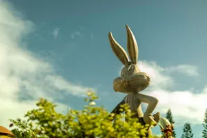 A whimsical Bugs Bunny statue set against a blue sky in a Gold Coast theme park. jigsaw puzzle
