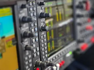 Detailed view of an aircraft cockpit instrument panel showcasing various control knobs and digital displays. jigsaw puzzle