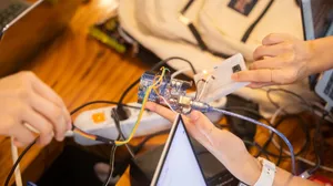 A detailed view of a team collaborating on an Arduino project featuring wiring and a breadboard. jigsaw puzzle