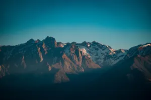 Breathtaking view of a majestic mountain range bathed in warm sunrise light. jigsaw puzzle