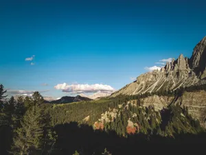 Capture of mountain range with clear sky and trees, showcasing natural beauty and tranquility. jigsaw puzzle