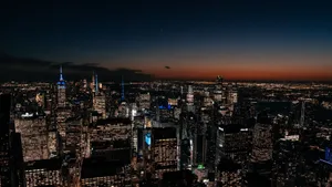 Aerial view of New York City skyline illuminated at dusk with vibrant city lights. jigsaw puzzle