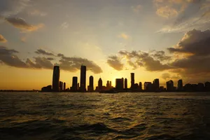 Capture the breathtaking New York City skyline under a vibrant sunset with sweeping clouds. jigsaw puzzle
