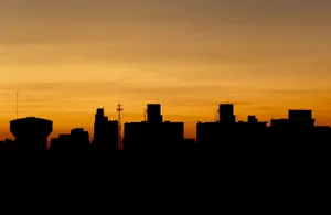 A dramatic silhouette of a city skyline against a vibrant golden sunset sky. jigsaw puzzle