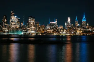 Marvelous view of New York City's illuminated skyline reflecting on the water at night. jigsaw puzzle