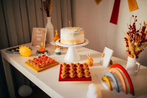 Colorful first birthday party table setup with cake and decorations indoors. jigsaw puzzle