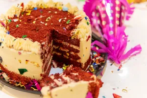 A vibrant red velvet cake with decorative confetti at a festive celebration. jigsaw puzzle