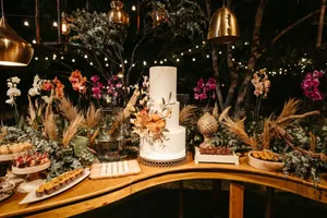 A beautifully decorated wedding cake with orchids and greenery under warm ambient lighting. jigsaw puzzle