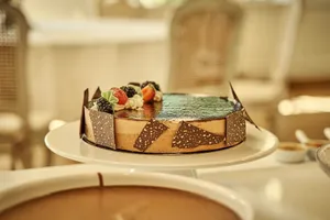 Delicious chocolate cake with fresh fruit toppings on an indoor white table setting. jigsaw puzzle