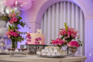 A beautifully decorated birthday cake with flowers and sweets on a table indoors, perfect for celebrations. jigsaw puzzle
