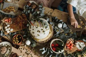 Top view of a rustic party table with birthday cake, appetizers, and decorations. jigsaw puzzle