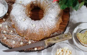 Appetizing bundt cake dusted with powdered sugar and chocolate chips on a rustic wooden board. jigsaw puzzle