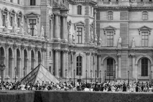 Monochrome image of the Louvre Pyramid surrounded by tourists in Paris, France. jigsaw puzzle