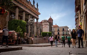 A bustling street scene in Guanajuato, Mexico, featuring the iconic Juarez Theater and local pedestrians. jigsaw puzzle