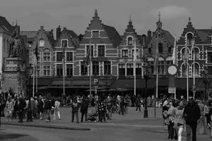 Black and white photo of Bruges Market Square with medieval buildings and a bustling crowd. jigsaw puzzle
