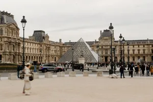 View of the Louvre Museum and iconic glass pyramid in Paris with visitors. jigsaw puzzle