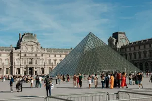 Crowds of tourists gather around the iconic Louvre Pyramid in Paris, France. jigsaw puzzle