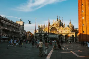 Tourists enjoying the vibrant atmosphere around St. Mark's Basilica in Venice during sunset. jigsaw puzzle
