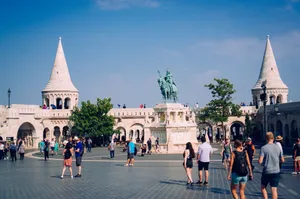 Tourists exploring Fisherman's Bastion and Saint Stephen statue in vibrant Budapest. jigsaw puzzle