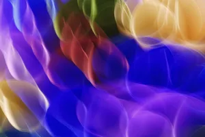 Dynamic abstract image featuring vibrant blurred light patterns in a mix of blue, red, green, and yellow colors. jigsaw puzzle